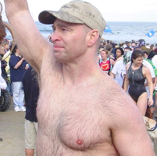 extremely hairy man jogging running polar plunge event beach